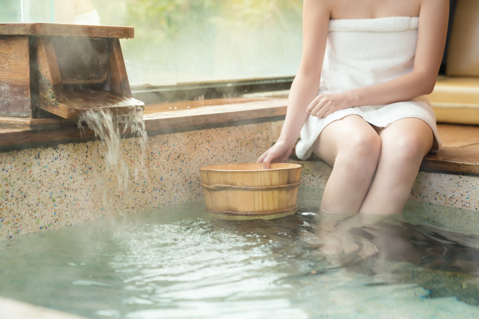 Eine Japanerin badet in einem Onsen